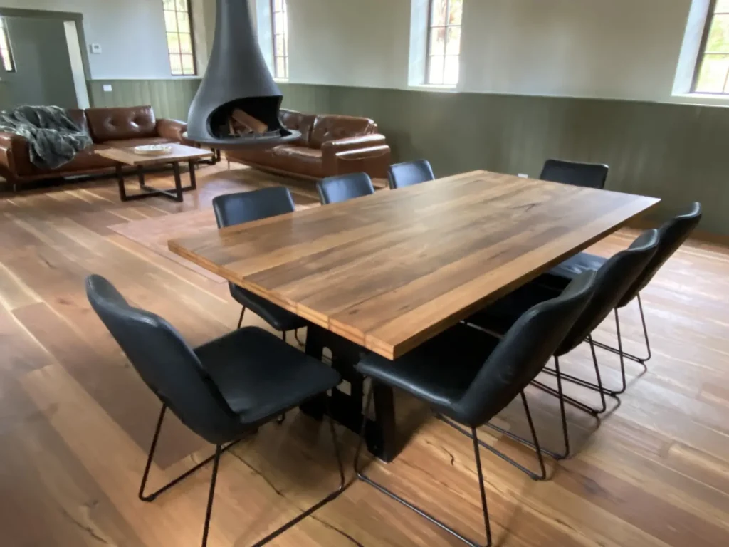 Custom timber dining table seating eight in an open-plan living space